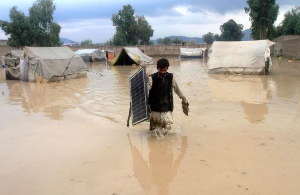 an afghan man wades through flood waters photo rueters