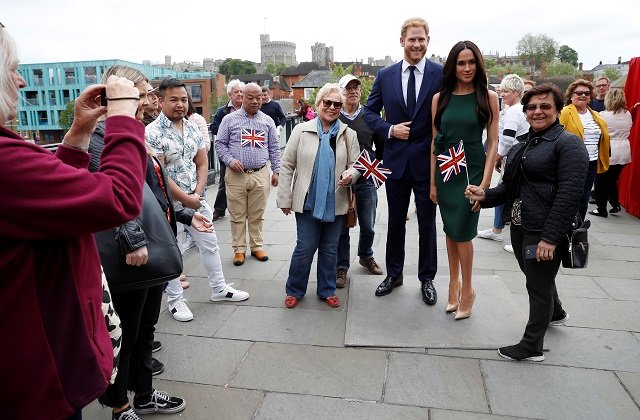 people pose for pictures with models of britain 039 s prince harry and meghan markle ahead of their wedding in windsor britain may 16 2018 photo reuters