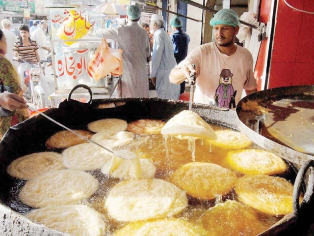 a man prepares pheni at his workplace in rawalpindi photo nni a man prepares pheni at his workplace in rawalpindi photo nni