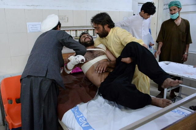 a victim is helped by relatives at a hospital after eight people were killed and 45 wounded in a series of explosions targeting a cricket stadium in jalalabad photo afp