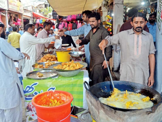 vendors making samosas and pakoras which are considered must items for iftari photo express vendors making samosas and pakoras which are considered must items for iftari photo express