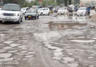 commuters try to avoid potholes on a road in the city the recent downpour has created craters on many roads exposing the quality of the work of the civic authorities photo express