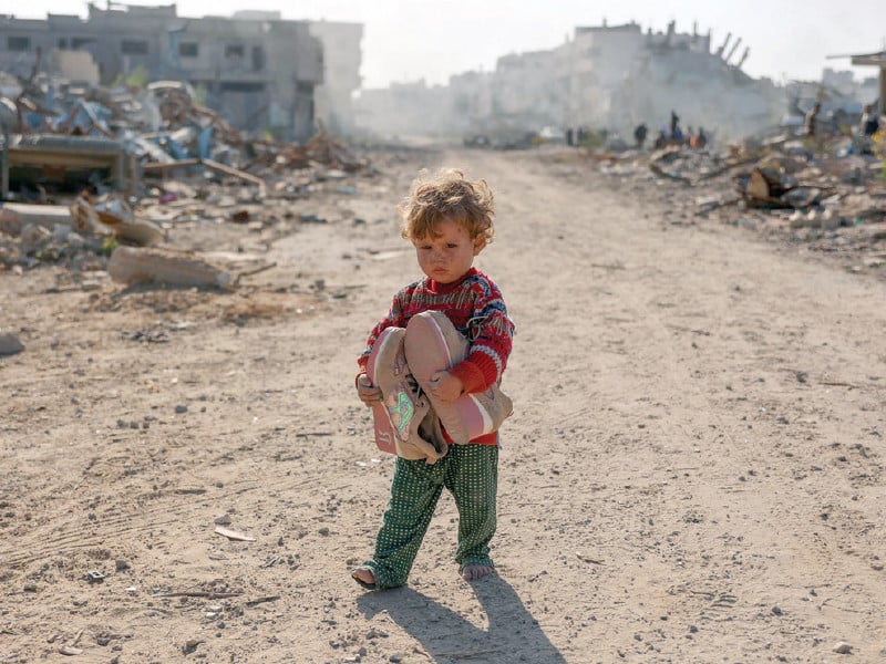 a displaced palestinian child fleeing beit lahia in the northern gaza strip walks on a road in gaza city photo afp