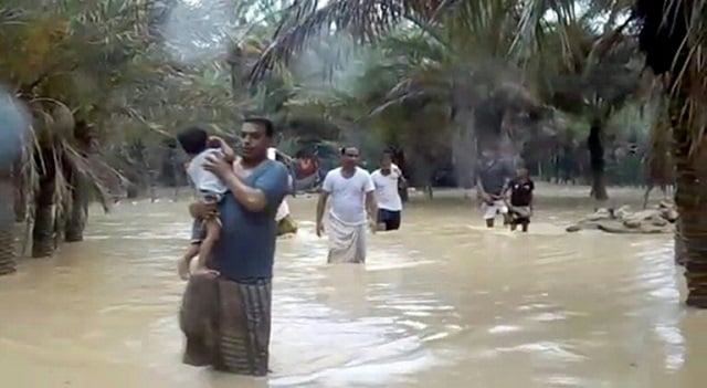 an image grab taken from an afptv video shows people walking through flood water as they evacuate a flooded area during a cyclone in the yemeni island of socotra photo afp