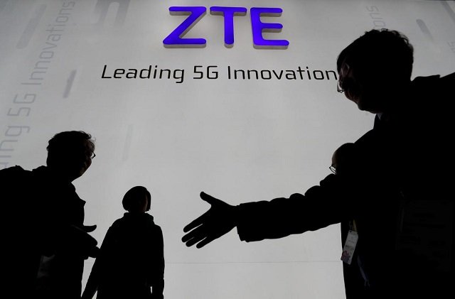 visitors pass in front of the chinese telecoms equipment group zte booth at the mobile world congress in barcelona spain february 26 2018 photo reuters