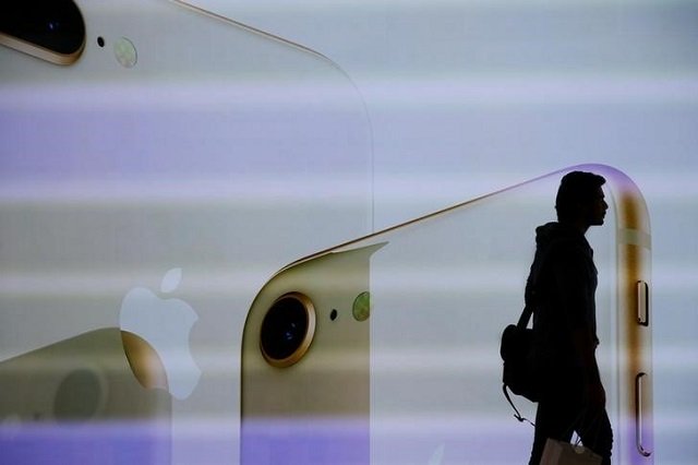 a customer walks past a large screen at the new apple visitor center in cupertino california us november 17 2017 photo reuters