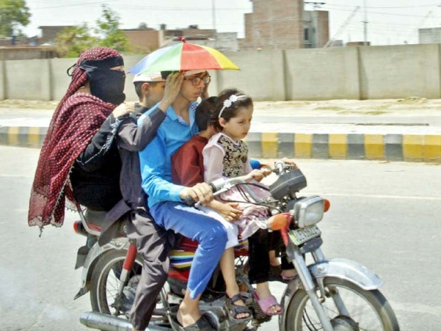 a boy dons an umbrella cap to ward off the harsh sun in lahore photo online a boy dons an umbrella cap to ward off the harsh sun in lahore photo online