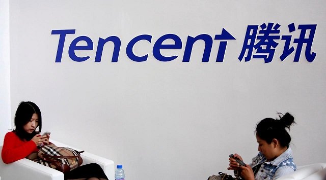 visitors use their smartphones underneath the logo of tencent at the global mobile internet conference in beijing may 6 2014 photo reuters