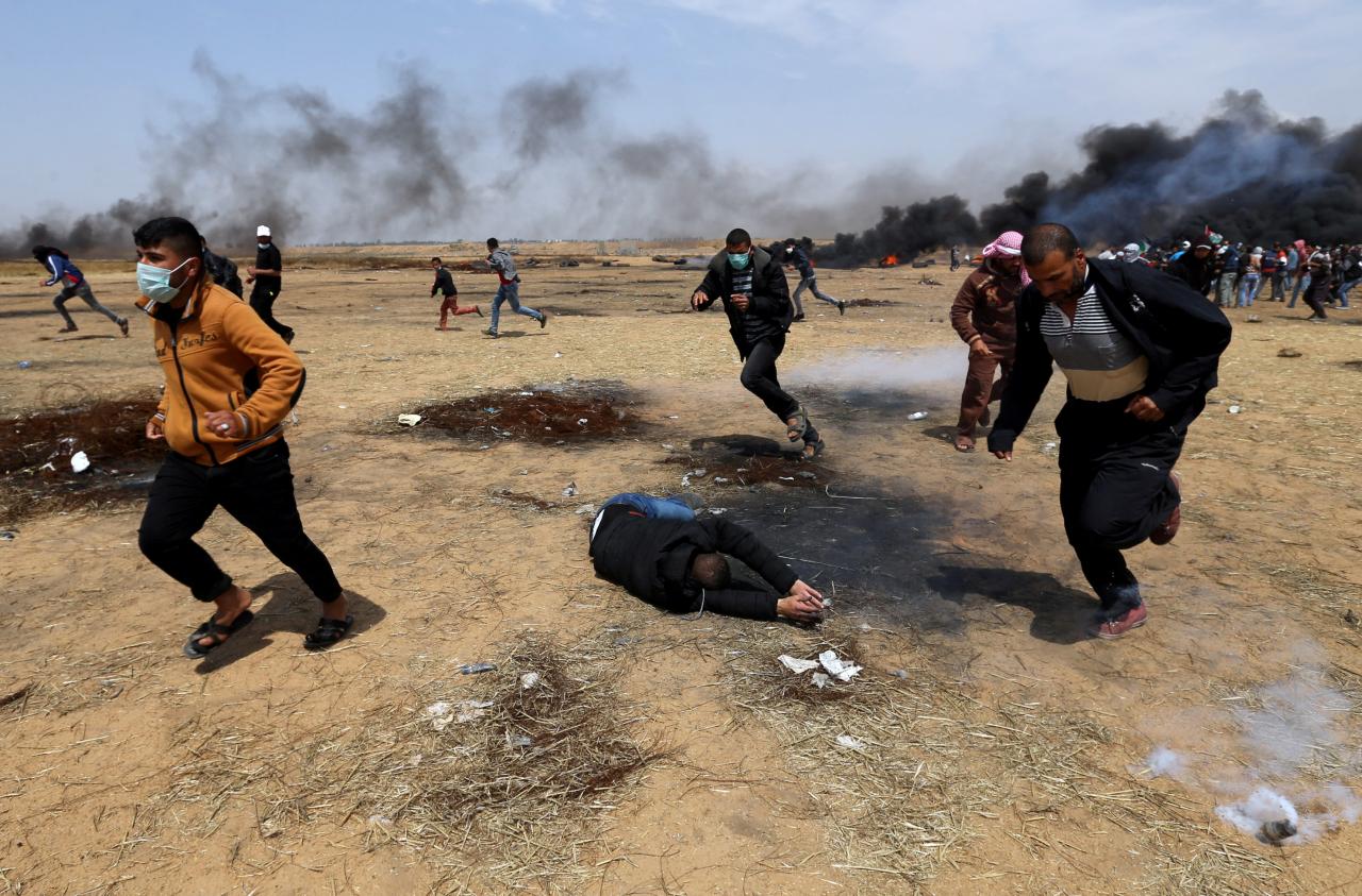 wounded palestinian falls on the ground during clashes with israeli troops at a protest where palestinians demand the right to return to their homeland at the israel gaza border in the southern gaza strip photo reuters