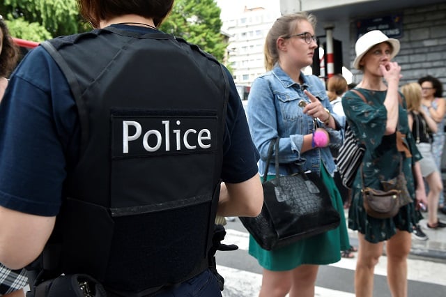 a police officer speaks with parents of children at a nearby high school in the eastern belgian city of liege on may 29 2018 after a man killed three people including two policemen photo afp