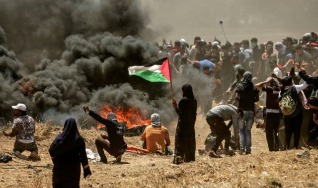a woman holds the palestinian flag during the gaza border protests photo afp a woman holds the palestinian flag during the gaza border protests photo afp