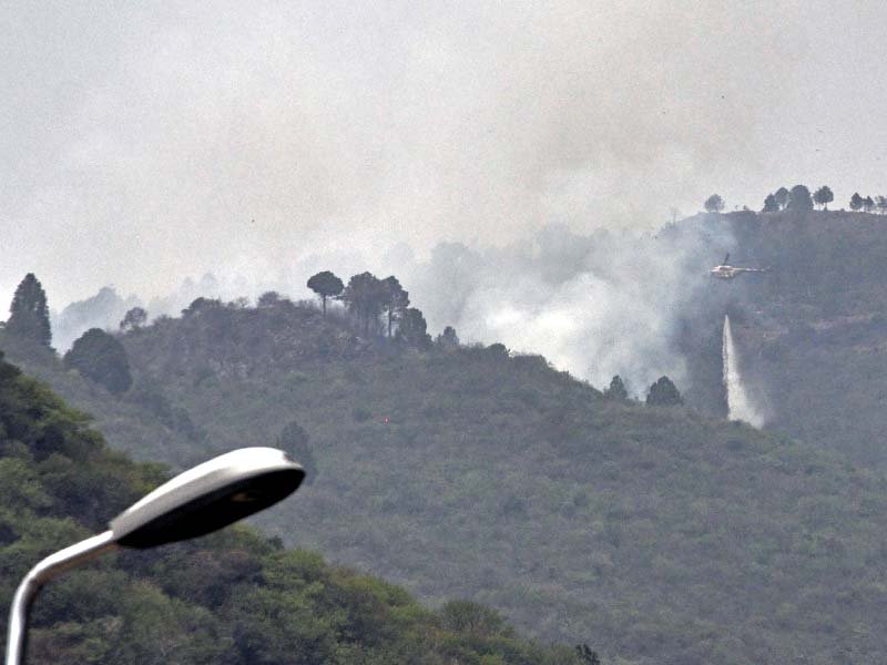 a paf helicopter drops water to douse the fire in margalla hills photo zafar aslam express