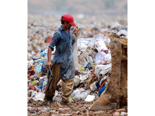 a rag picker collects recyclable materials at a garbage dump in islamabad photo afp a rag picker collects recyclable materials at a garbage dump in islamabad photo afp