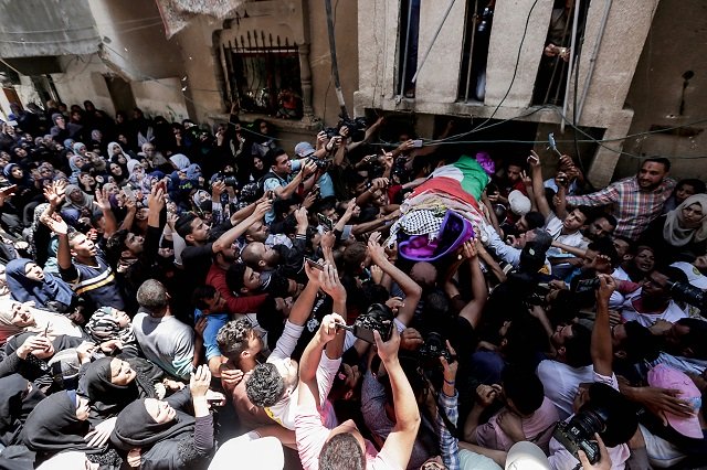 palestinian mourners carry the body of 21 years old razan al najjar during her funeral after she was shot dead by israeli soldiers in khan yunis on june 2 2018 photo afp