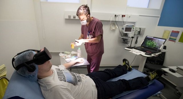 a nurse treats a patient wearing the 3 d therapeutic virtual reality headset developed by the healthy mind startup at the emergency services department of the saint joseph hospital in paris june 7 2018 photo reuters