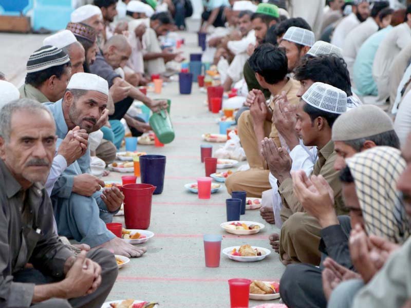 people wait to open fast at an iftar arranged by local volunteers photo inp