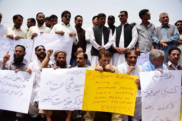 kashmiri journalists and residents hold placards during a protest against the killing of kashmiri editor in chief of the srinagar based newspaper rising kashmir shujaat bukhari in muzaffarabad on june 15 2018 photo afp