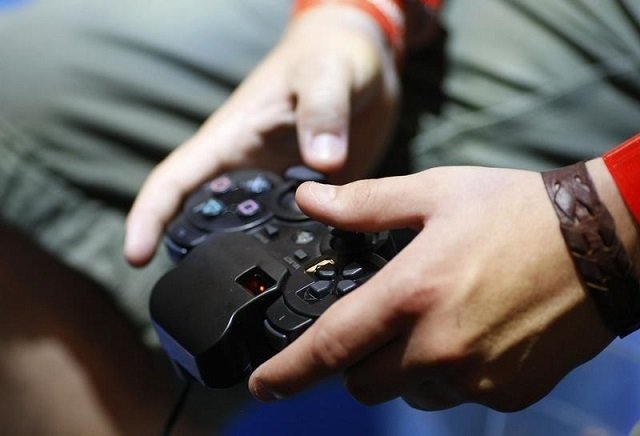 a visitor plays with a 039 playstation 039 at an exhibition stand at the gamescom 2009 fair in cologne august 22 2009 photo reuters