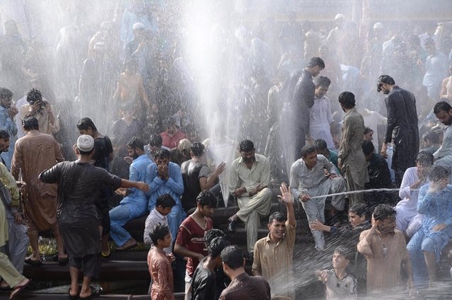 residents of haroonabad beat the heat by showering in the water of a leaky pipeline photo mohammad noman express