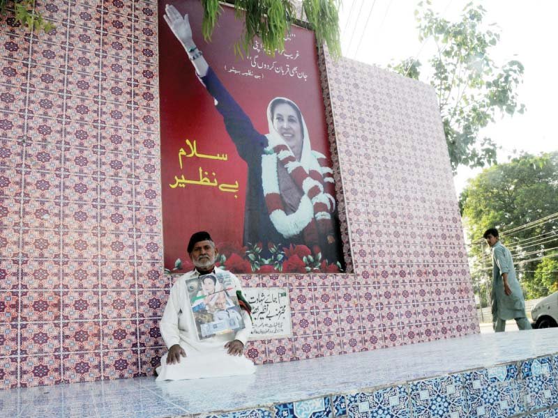 a man sits in front of benazir bhutto s monument on her birthday photo agha mehroz