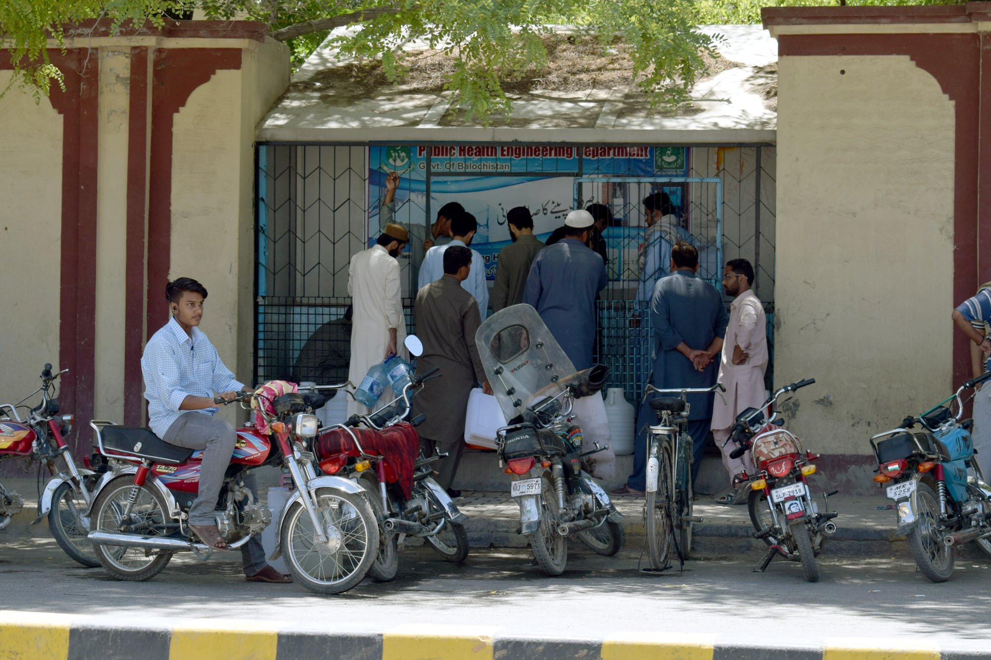 people wait outside a filtration plant to fill cans with drinking water in quetta photo express