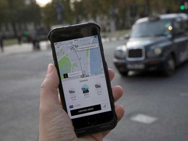 a photo illustration shows the uber app on a mobile telephone as it is held up for a posed photograph with a london taxi in the background in london britain november 10 2017 photo reuters