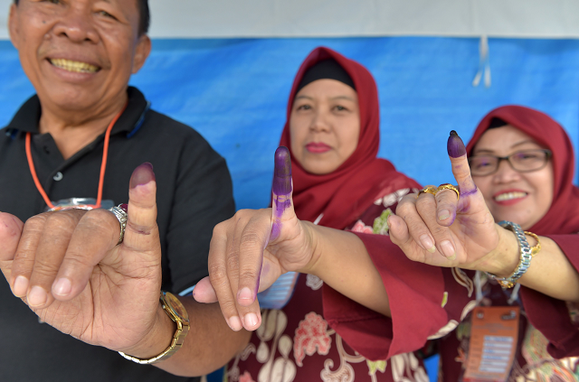 indonesian people show their inked fingers after casting their ballots during regional elections in tangerang photo afp