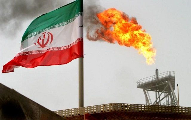 a gas flare on an oil production platform in the soroush oil fields is seen alongside an iranian flag in the persian gulf iran photo reuters