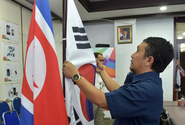 an official from the indonesian asian games organizing committee inasgoc prepares korean flags prior to a meeting with olympic council of asia at its headquarter in jakarta photo afp an official from the indonesian asian games organizing committee inasgoc prepares korean flags prior to a meeting with olympic council of asia at its headquarter in jakarta photo afp