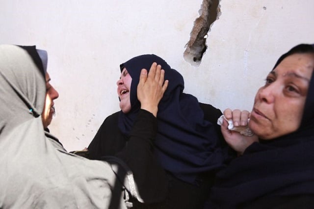 palestinian relatives of 11 year old yasser abu al naja son of a hamas military commander grieve at his funeral in the gaza strip on june 30 2018 a day after he was killed by israeli fire during border clashes photo afp