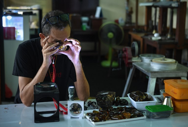 akbar khan a 52 year old self described 039 extreme fossil in amber hunter 039 inspects fossilised tree sap from myanmar photo afp