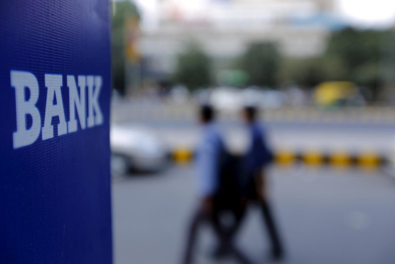 commuters walk past a bank sign photo reuters