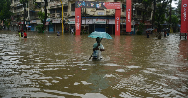 an indian man in the middle of a flooded street photo afp