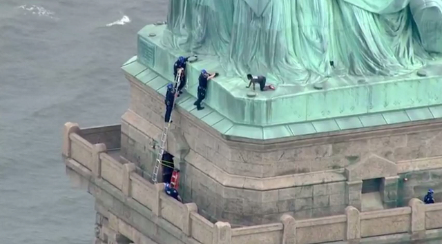 police pluck woman who scaled statue of liberty photo afp police pluck woman who scaled statue of liberty photo afp