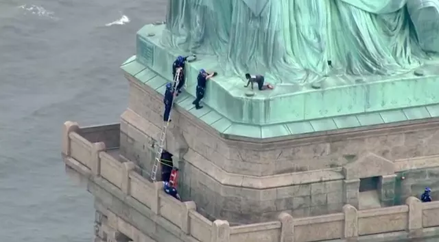 police pluck woman who scaled statue of liberty photo afp police pluck woman who scaled statue of liberty photo afp