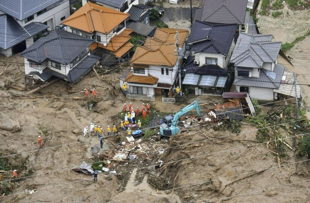 rescue workers are seen next to houses damaged by a landslide following heavy rain in hiroshima western japan in this photo taken by kyodo july 7 2018 photo reuters