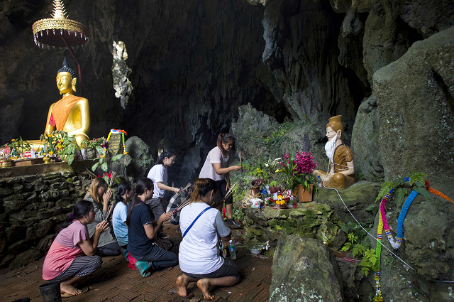 family members pray before a shrine in tham luang cave area as operations continue for the 12 boys and their coach trapped at the cave at khun nam nang non forest park in the mae sai district photo afp family members pray before a shrine in tham luang cave area as operations continue for the 12 boys and their coach trapped at the cave at khun nam nang non forest park in the mae sai district photo afp