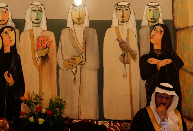 a guest sits under an arabic painting display at the lobby of al koot heritage hotel in al ahsa saudi arabia july 8 2018 photo reuters