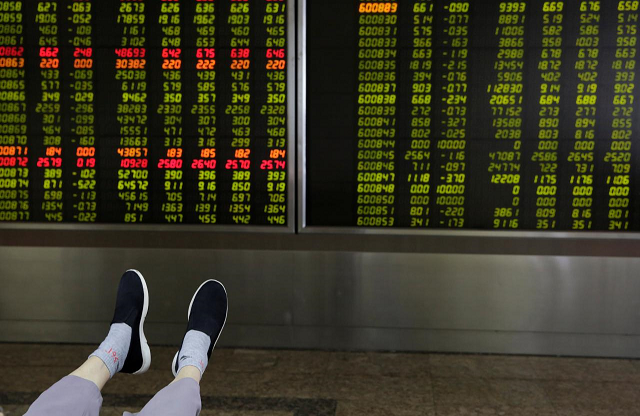 the feet of an investor are pictured as he looks at a board showing stock prices at a brokerage office in beijing china july 6 2018 photo reuters