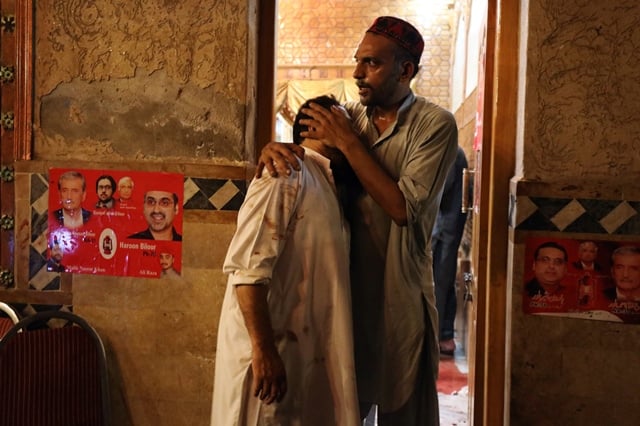 a party worker comforts another after the attack that killed at least 20 people photo reuters