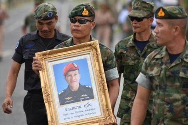 an honour guard hold up a picture of samarn kunan 38 a former member of thailand 039 s elite navy seal unit who died working to save 12 boys and their soccer coach trapped inside a flooded cave at an airport in rayong province thailand july 6 2018 photo reuters an honour guard hold up a picture of samarn kunan 38 a former member of thailand 039 s elite navy seal unit who died working to save 12 boys and their soccer coach trapped inside a flooded cave at an airport in rayong province thailand july 6 2018 photo reuters