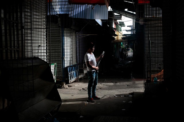 a man stands with a shotgun in front of stalls closed during a national strike at the oriental market considered one of central america 039 s largest markets in managua nicaragua july 13 2018 photo reuters