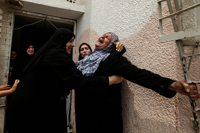 palestinians and relatives mourn over the death of 15 year old protester othman rami halles during his funeral east of gaza city on july 14 2018 photo afp palestinians and relatives mourn over the death of 15 year old protester othman rami halles during his funeral east of gaza city on july 14 2018 photo afp