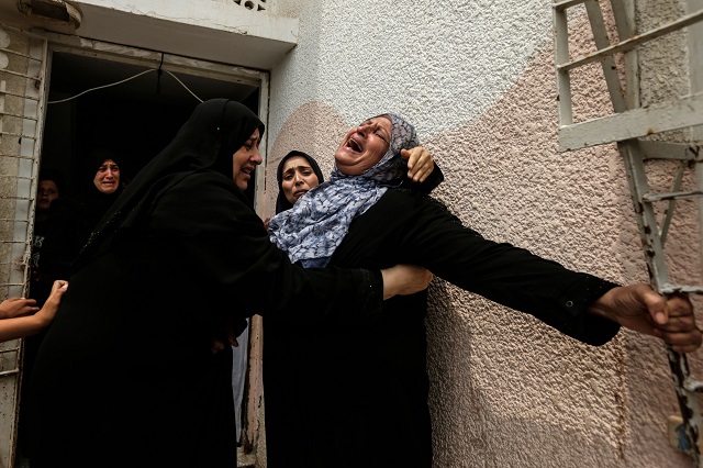 palestinians and relatives mourn over the death of 15 year old protester othman rami halles during his funeral east of gaza city on july 14 2018 photo afp