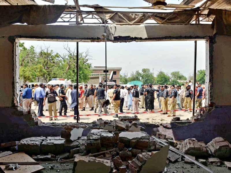 security officials gather at the site of the suicide bomb attack in peshawar on sunday photo afp