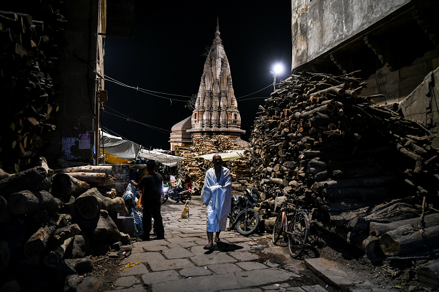 an indian man walking through the manikarnika ghat in the old quarters of varanasi photo afp an indian man walking through the manikarnika ghat in the old quarters of varanasi photo afp