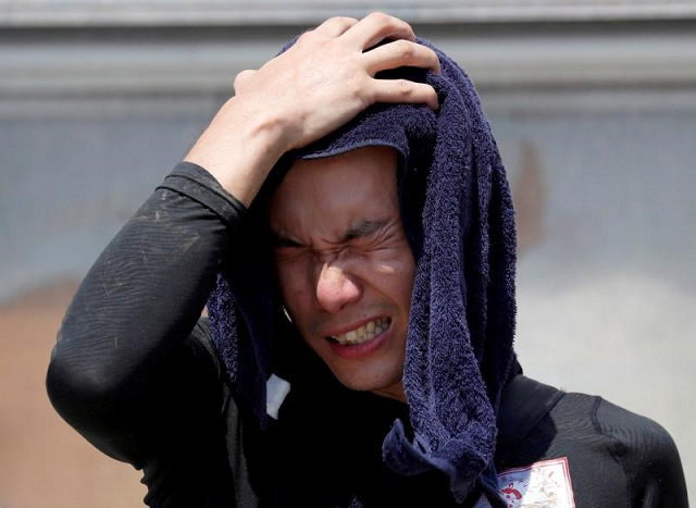 a volunteer wipes sweat during a heatwave in japan photo reuters