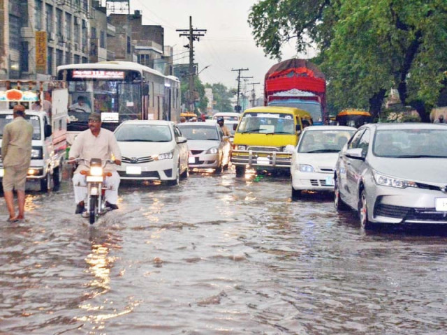 vehicles wade through rainwater accumulated on roads in faisalabad photo online vehicles wade through rainwater accumulated on roads in faisalabad photo online