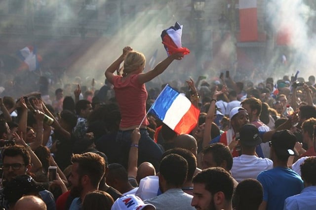 supporters wave french national flags as they greet and welcome france 039 s team players parading down the champs elysees avenue in paris on july 16 2018 after france won the russia 2018 world cup final football match on the previous night photo afp