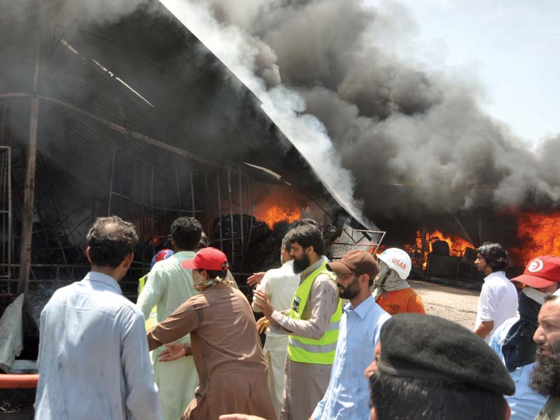 firefighters try to extinguish fire at the sector h 9 sunday bazaar while vendors look at the goods they could salvage photo zafar aslam express